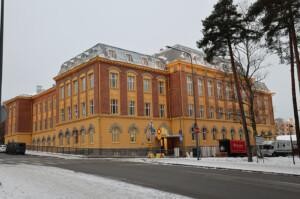 Puna-keltainen historiallinen rakennus, jossa kaari-ikkunoita.