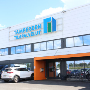 Rakennuksen ulkoseinää, jossa Tampereen Tilapalvelujen valomainos.