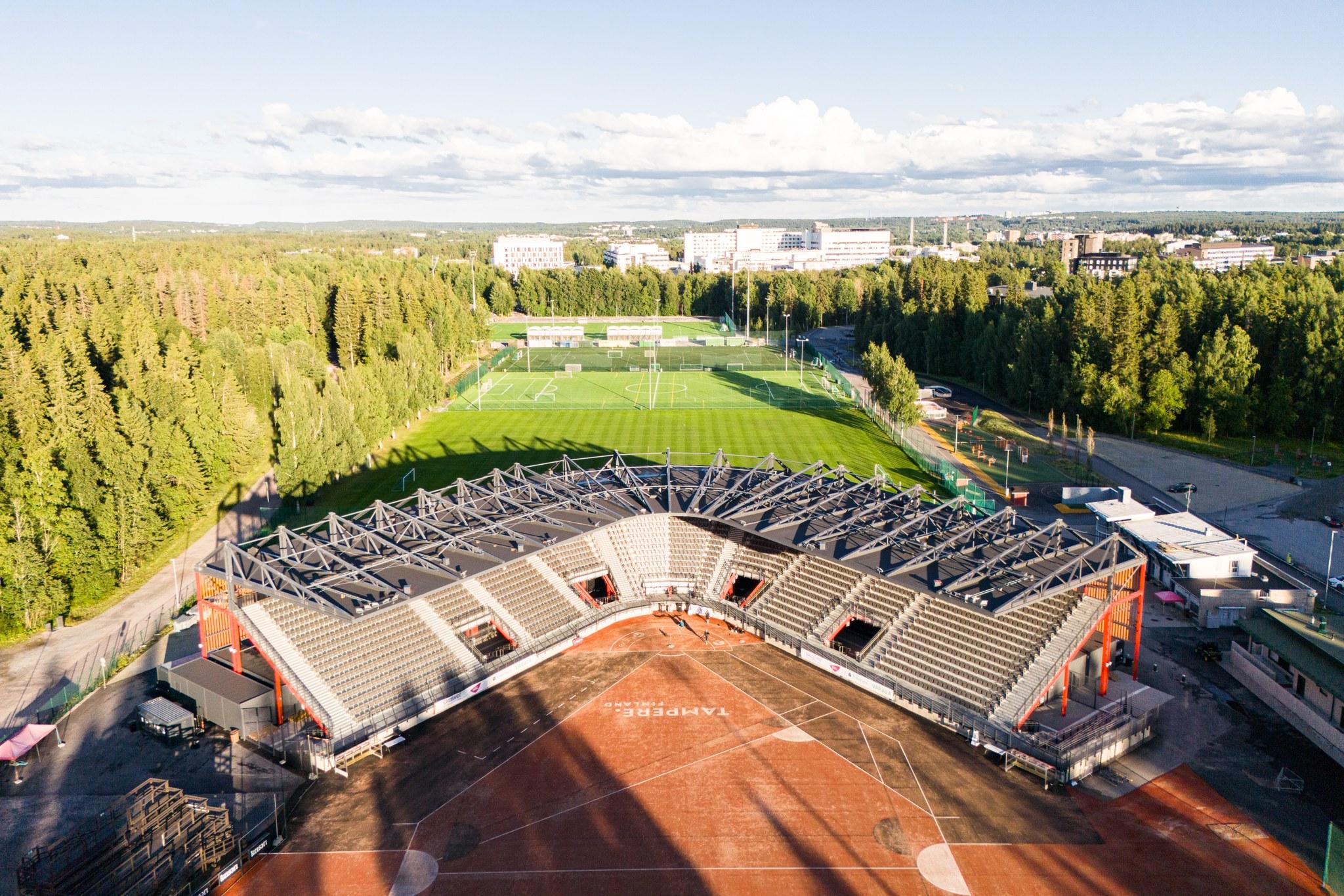 Puolikaaren muotoinen katsomorakennus, jonka edessä pesäpallokenttä.